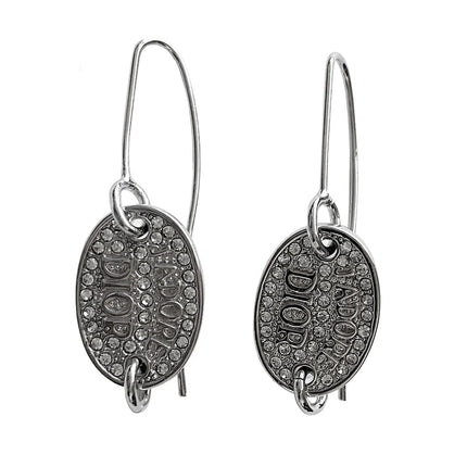 Silver oval shaped Christian Dior earrings with the text JADORE and DIOR beneath and both surrounded by rhinestones