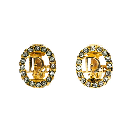 Oval shaped Christian Dior gold clip on earrings with Dior logo in center and crystals surrounding